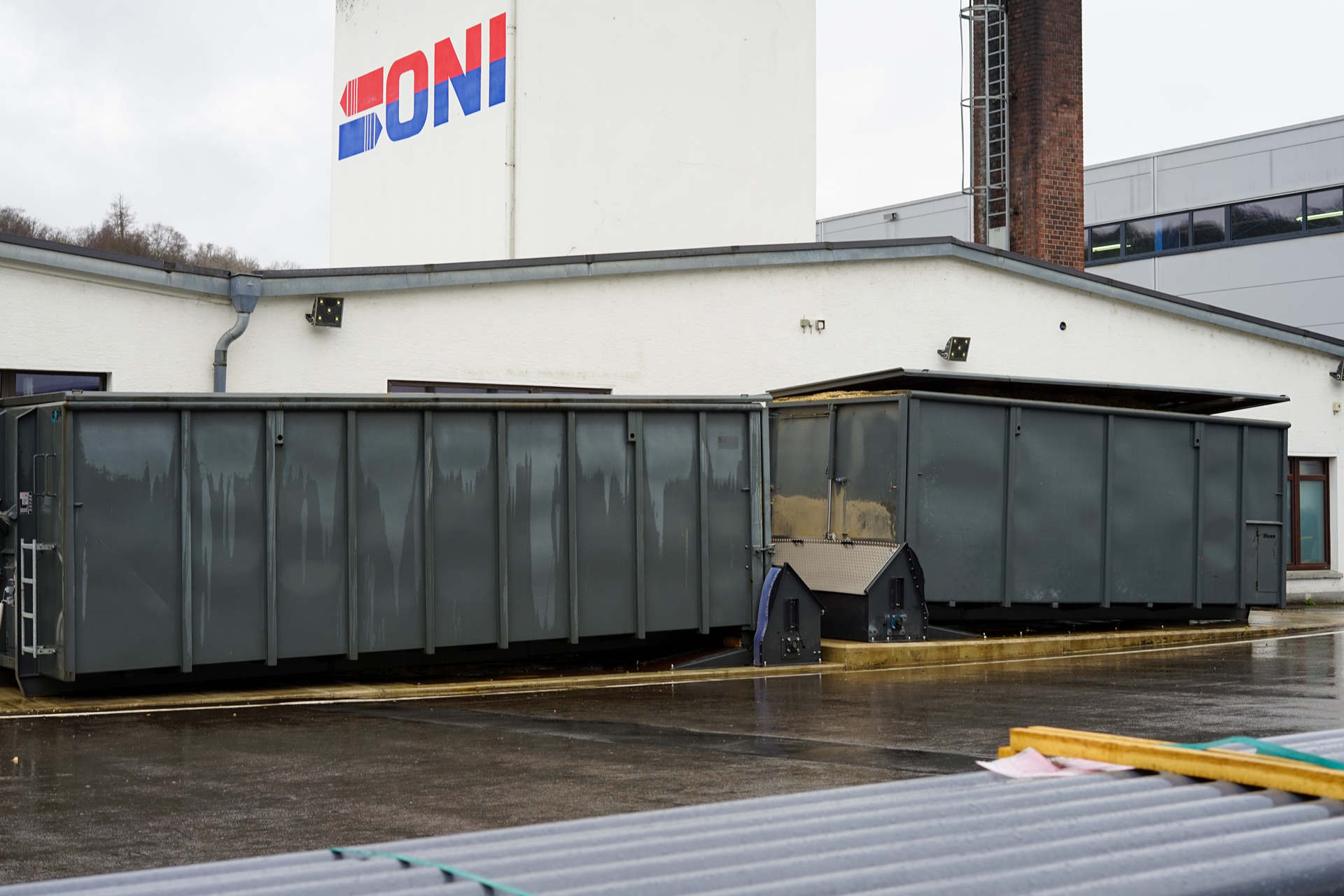 Graue Schubbodencontainer in einer Dockingstation auf einem Firmengelände