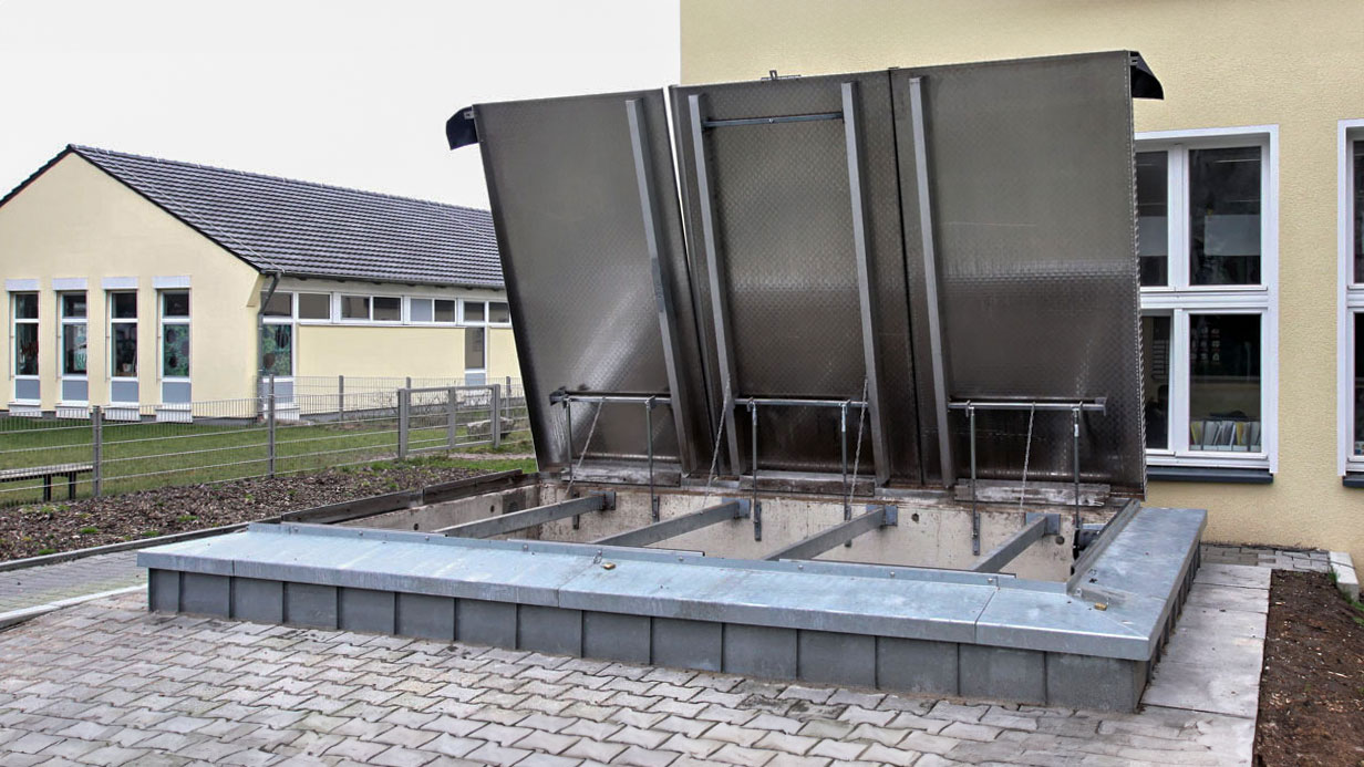 Erdbunker mit einer geöffneten Metalklappe