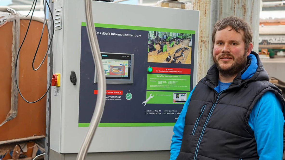 biomasseheizung-gartenbau-referenzen Kunde vor einem Schaltschrank von dp Energietechnik