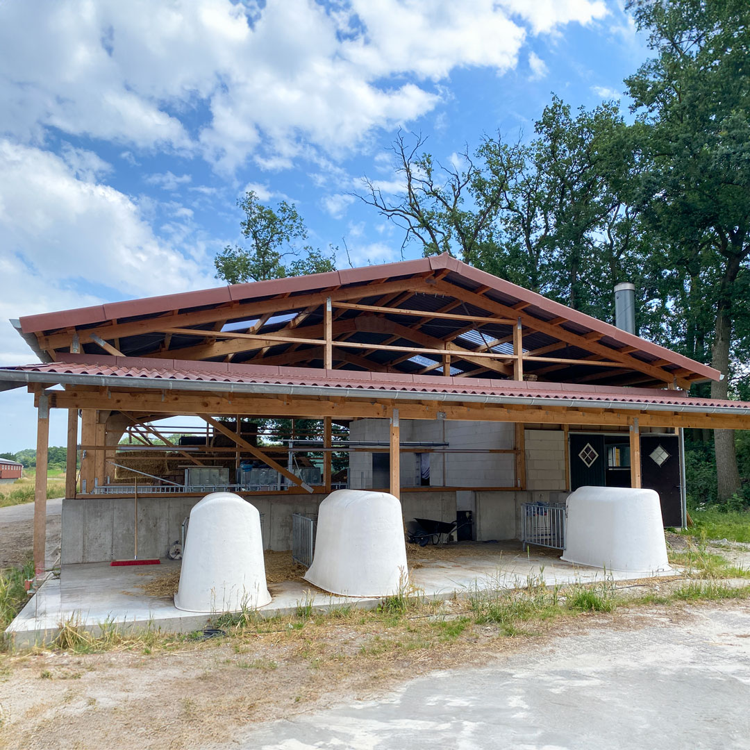 Halle aus Holzständerwek vor blauem Himmel