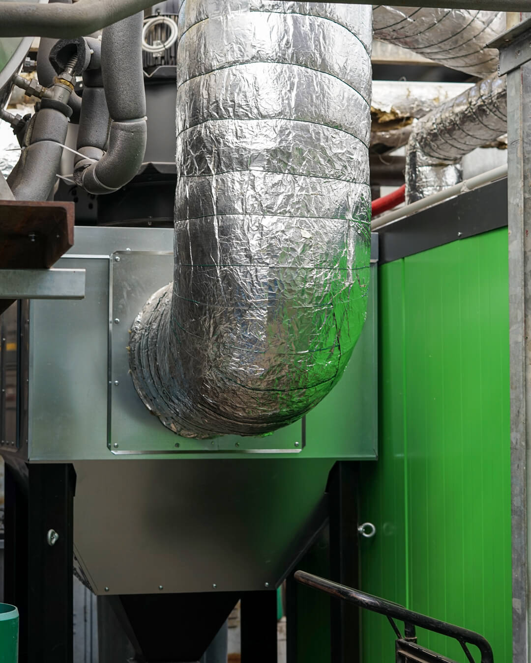 prozesswärme-biomasseheizung-multizyklon Multizyklon mit Aluminiumisolierung neben einer Biomasseheizung von Heizomat