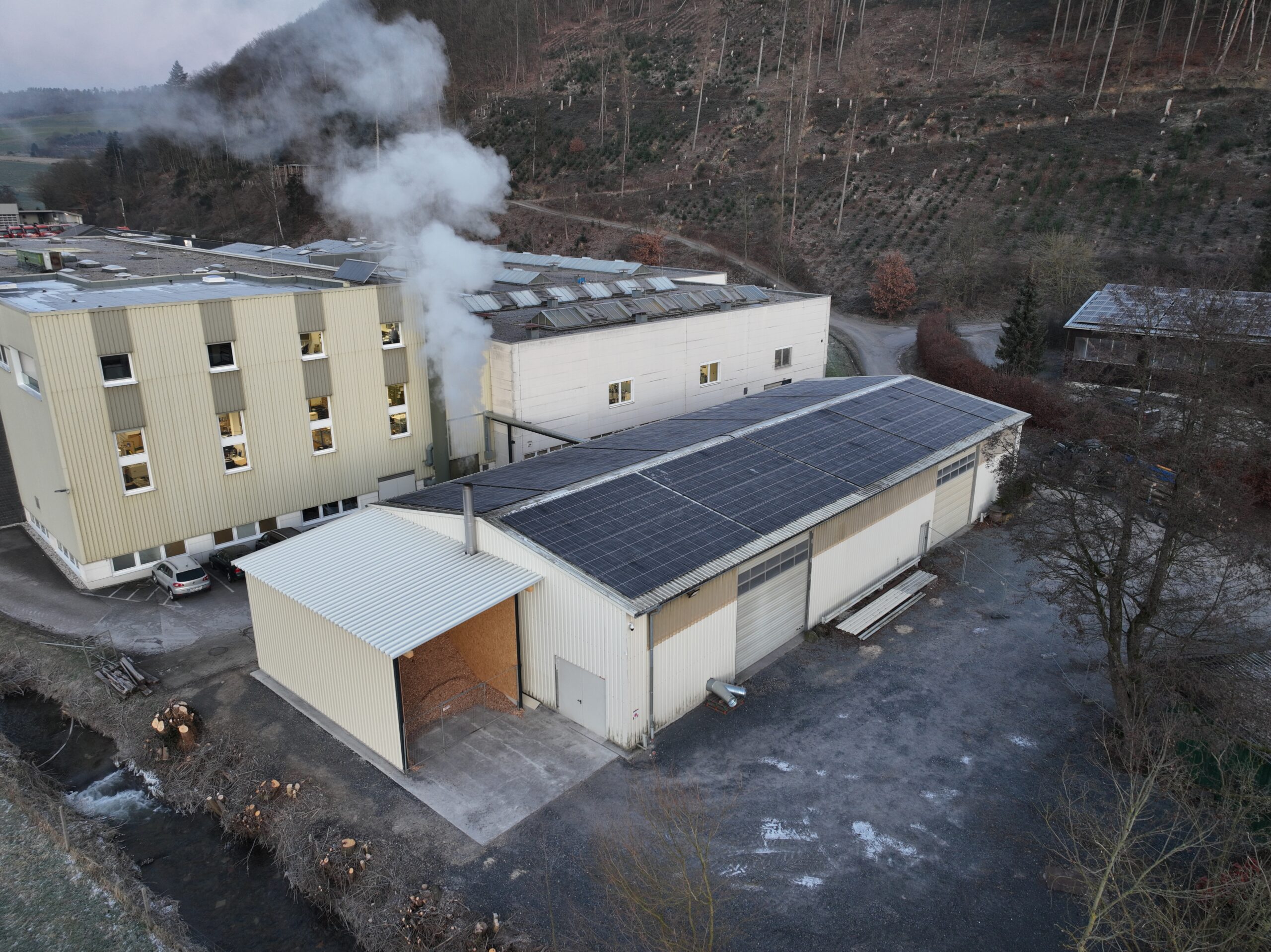 default Heizzentrale mit außenliegendem Hackschnitzelbunker, Edelstahlkamin und Anschlüssen für die Trocknungsanlage