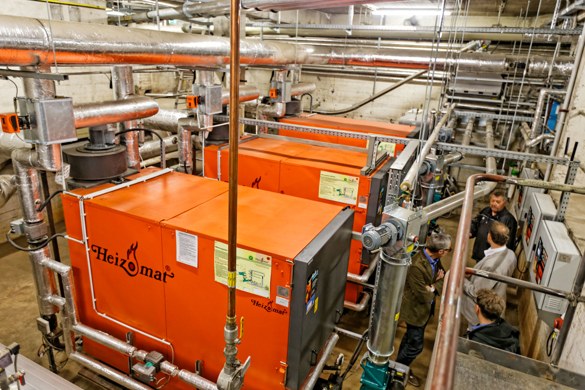 holzpellets-kaskade-heizomat Drei Heizomat Pelletheizungen in Heizraum eines Schulgebäudes