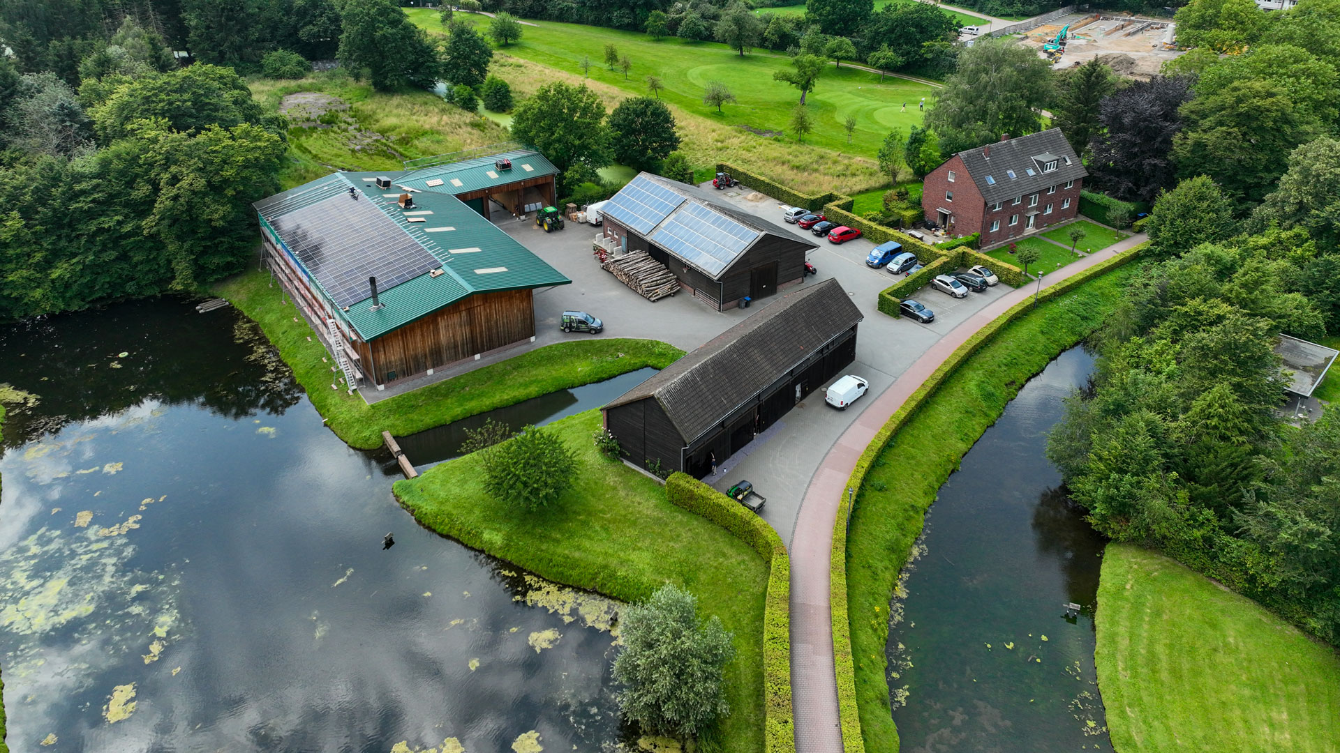 Heizzentrale mit grünem Blechdach in einer Parkanlage