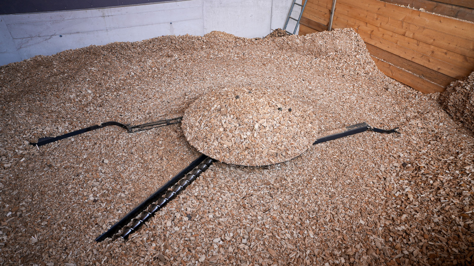 bunkerfräse-hackschnitzel-lager Gelenkarmaustragung mit patentierter Paralelfräse in einem Hackschnitzelbunker