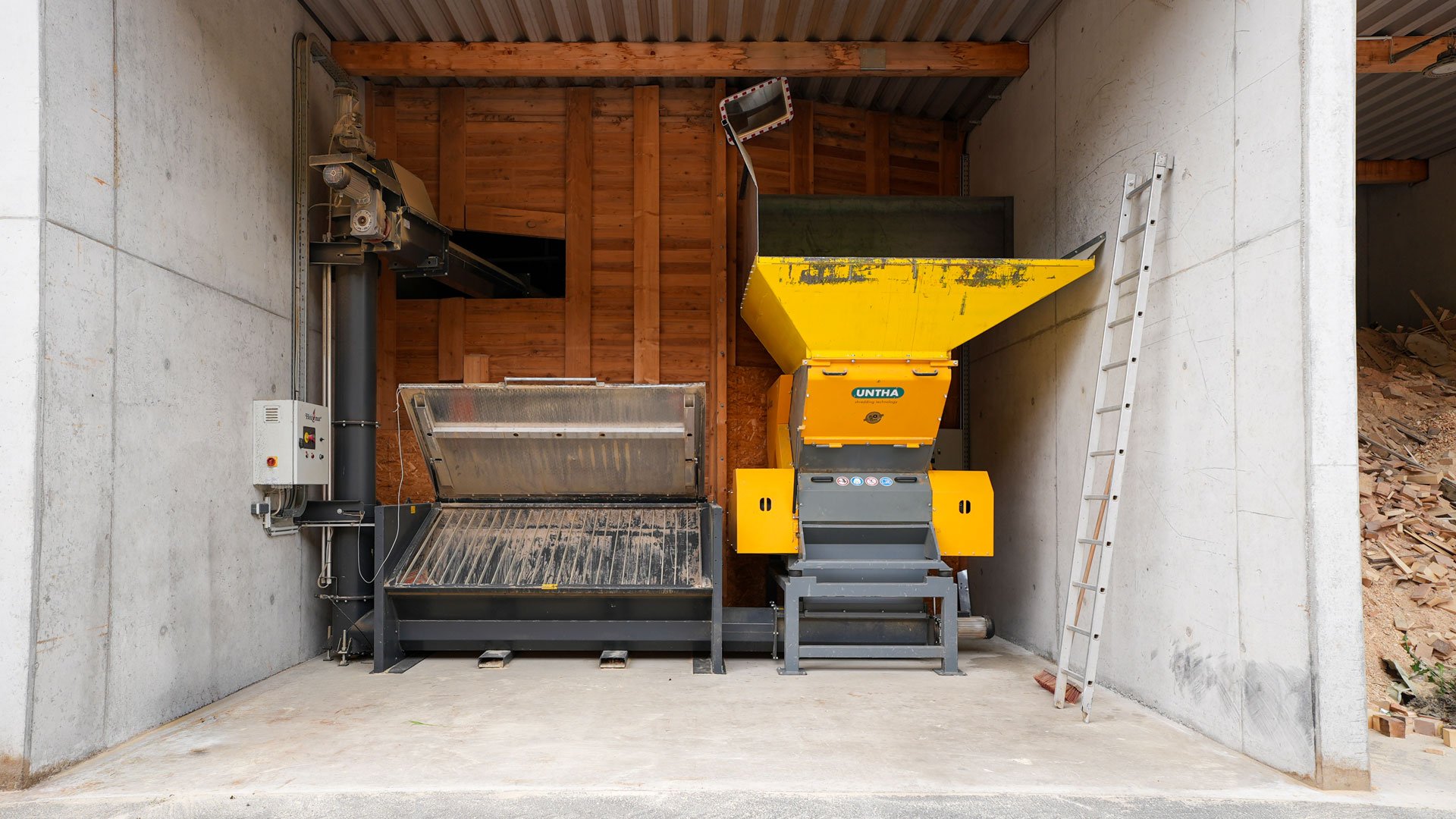 Gelber Untha Holzschredder für Altholz und Bunkerbefüllsystem für Hackschnitzel