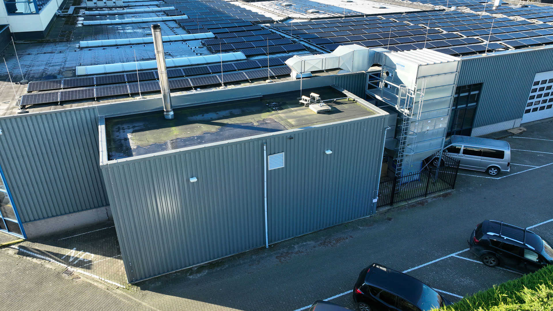 Heizzentrale neben einer Industriehalle mit PV Modulen auf dem Dach