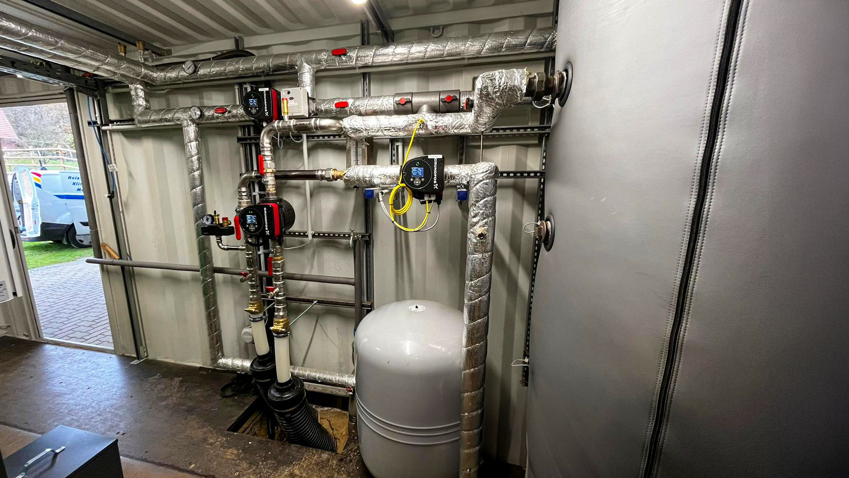 Heizcontainer mit Pufferspeicher und isolierten Heizungsrohren