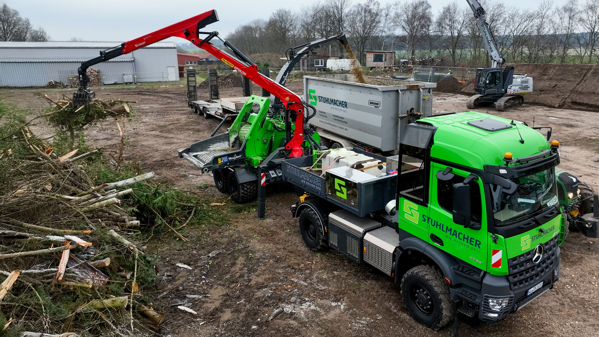 forstlkw-heizotruck-hackschnitzel Grüner Heizotruck V1 vor einem HM 14-860 Holzhacker beim Holzhacken