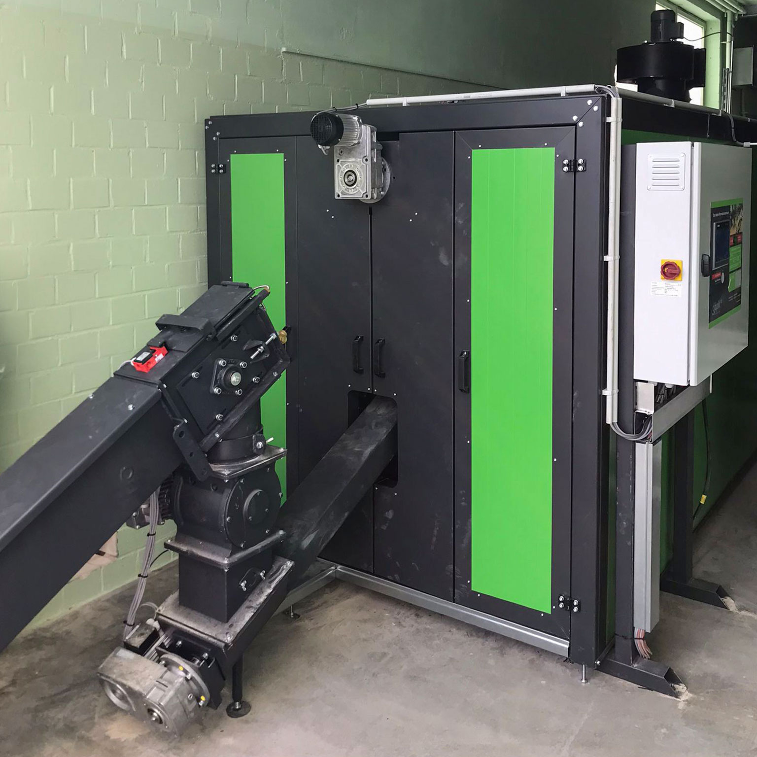biomasseheizung-industrie-heizomat Grüne Biomasseheizung mit Zellenradschleuse und Schaltschrank