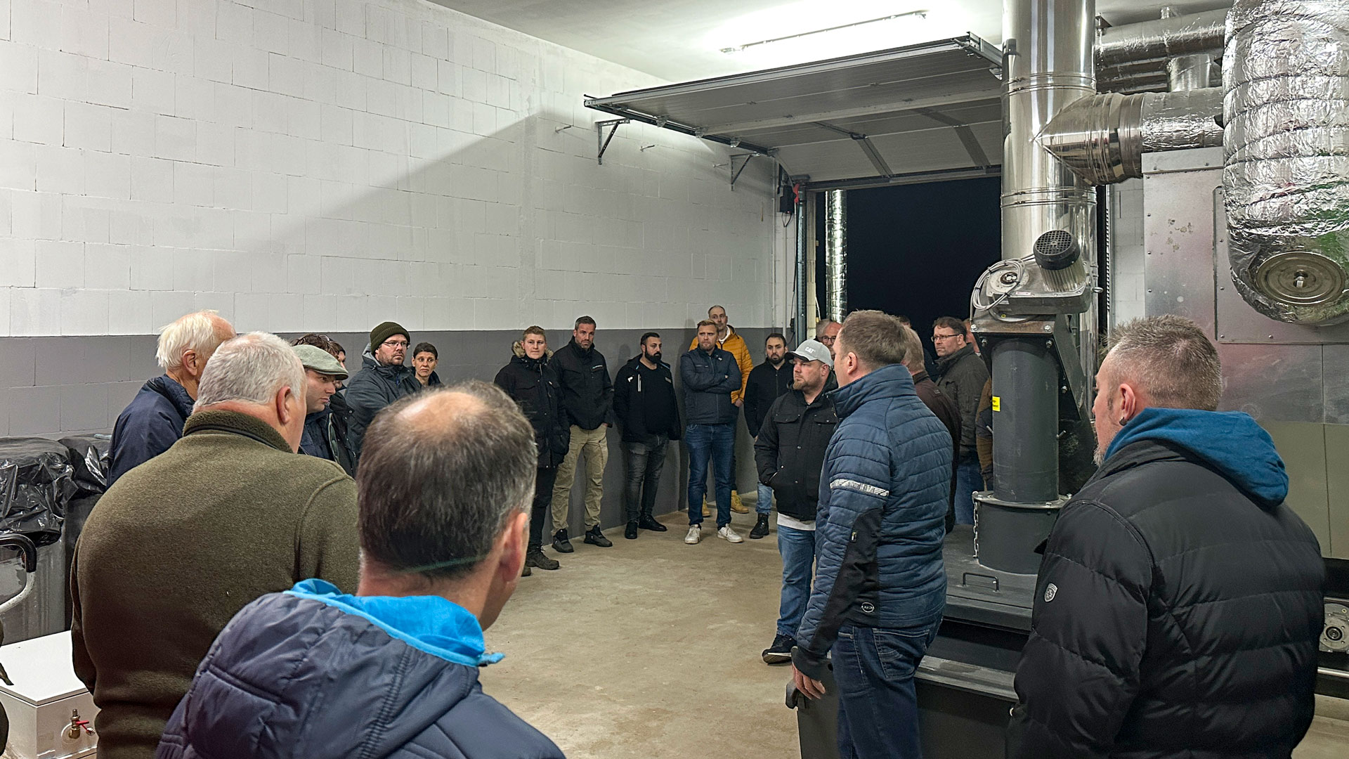 infoveranstaltung-waermenetz-biomasse Mehrere Personen bei der Vorführung und Begehung einer Biomasseheizung