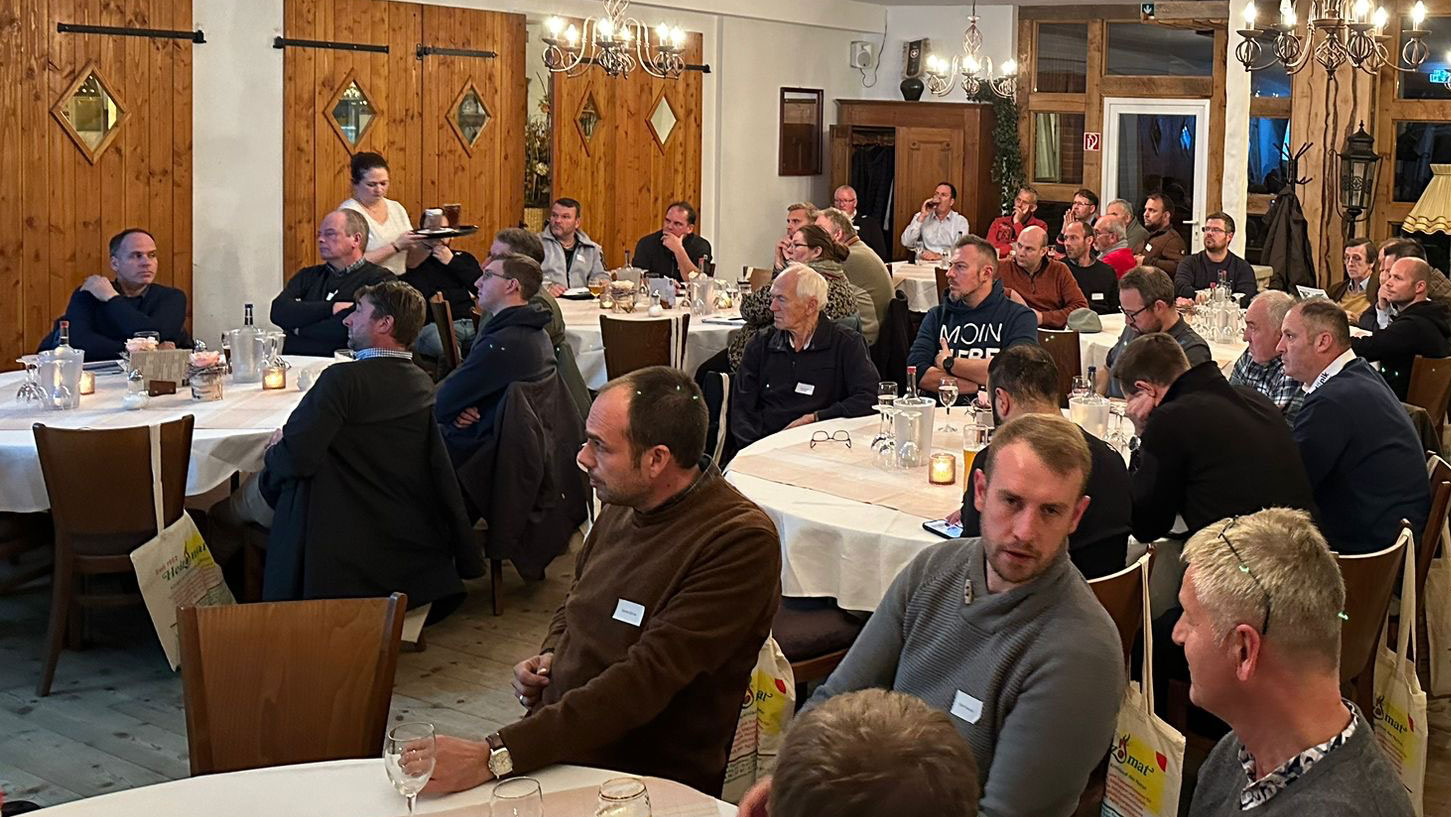 vortrag-biomasse-nahwaerme Personen an Tischen bei einem Vortrag zu Biomasseheizungen und Nahwärmenetzen