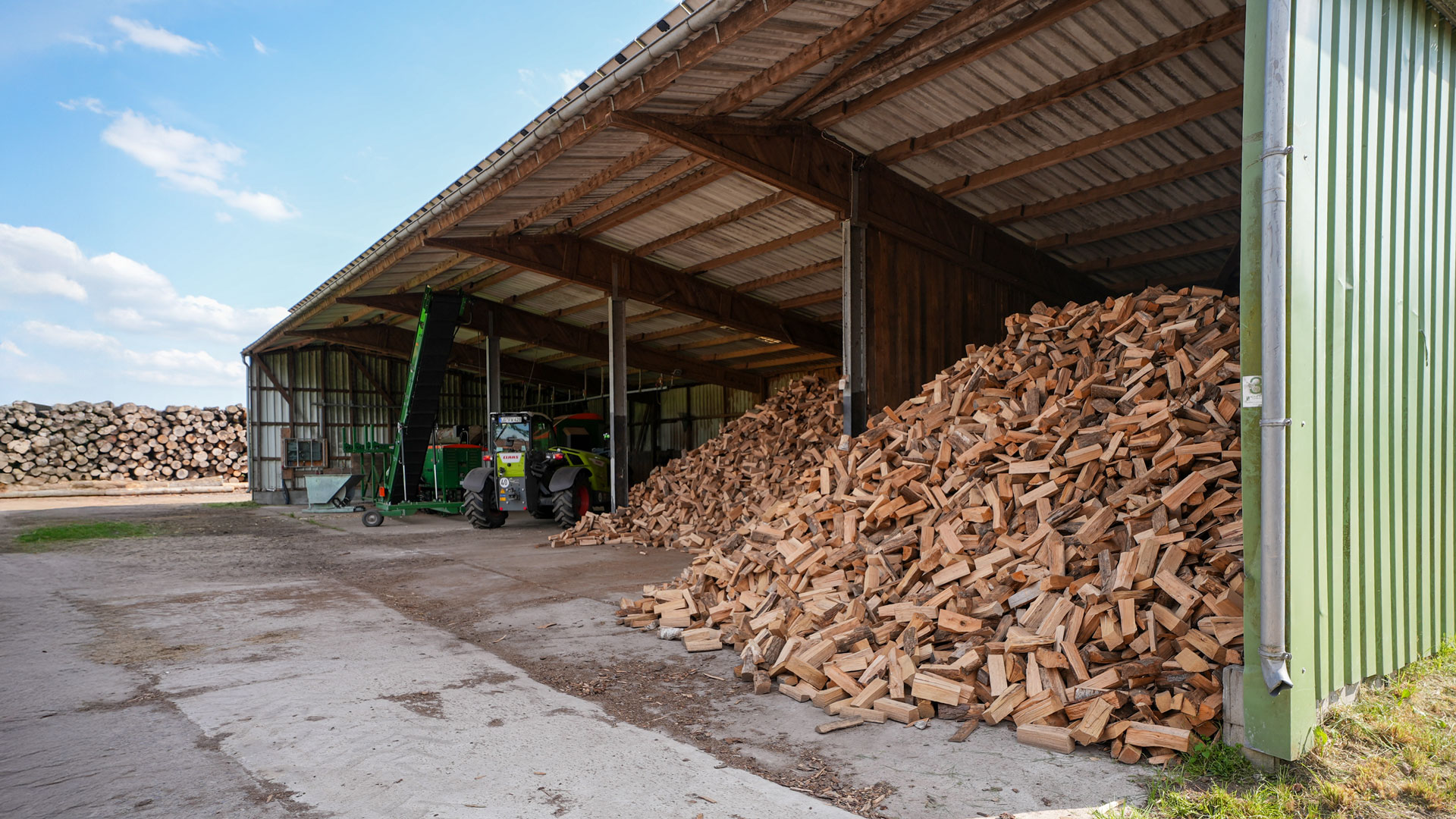 Eine große offene Schirmschoppe mit Stückholz-Lager