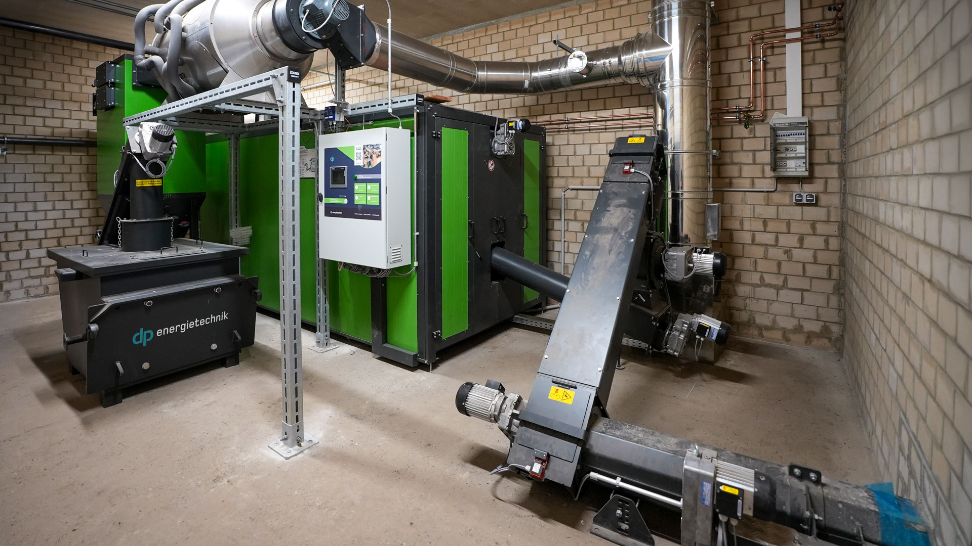 heizraum-hackschnitzelheizung-heizomat Heizzentrale mit einer Biomasseheizung von Heizomat und Zellenradschleuse