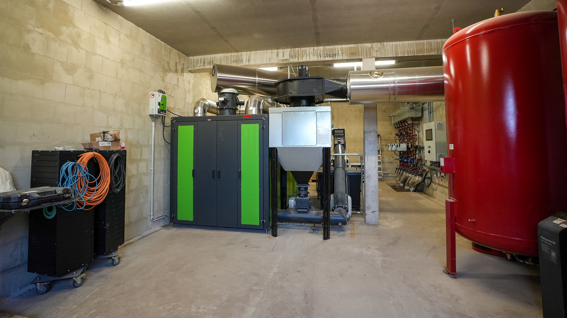 heizzentrale-hackschnitzelheizung-pufferspeicher Heizzentrale mit einer grünen Heizomat Biomasseheizung