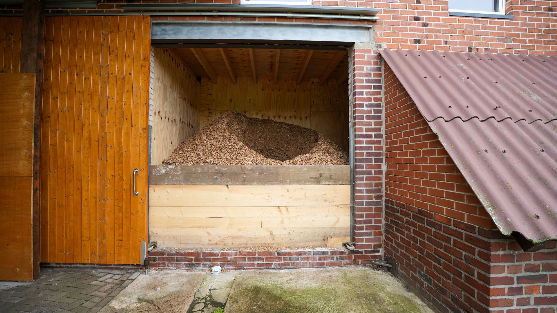Selbstgebauter Brennstoffbunker hinter einer großen Schiebetür