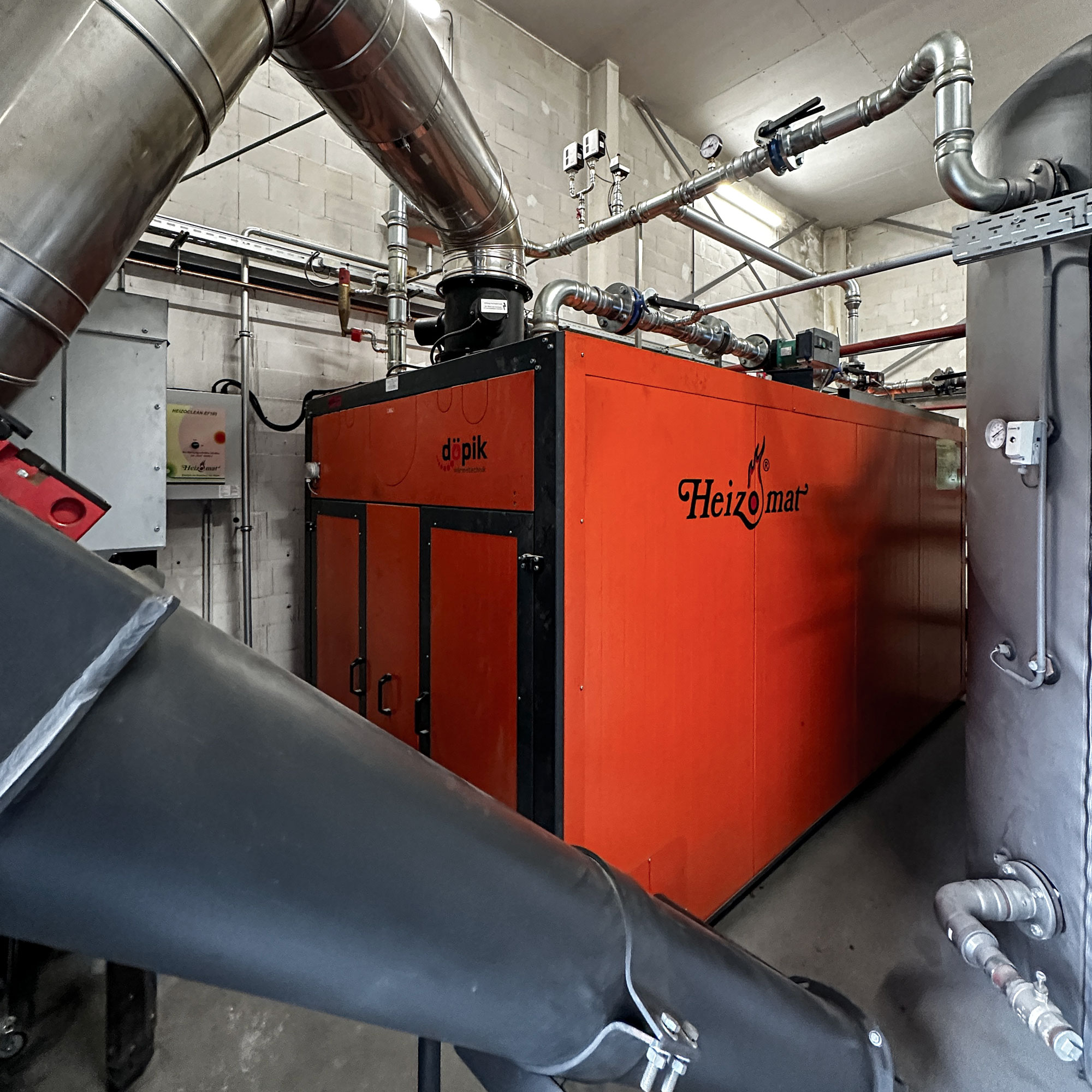 foerderkette-asche-holzheizung Heizungsraum mit einer Hackschnitzelheizung und Pufferspeicher