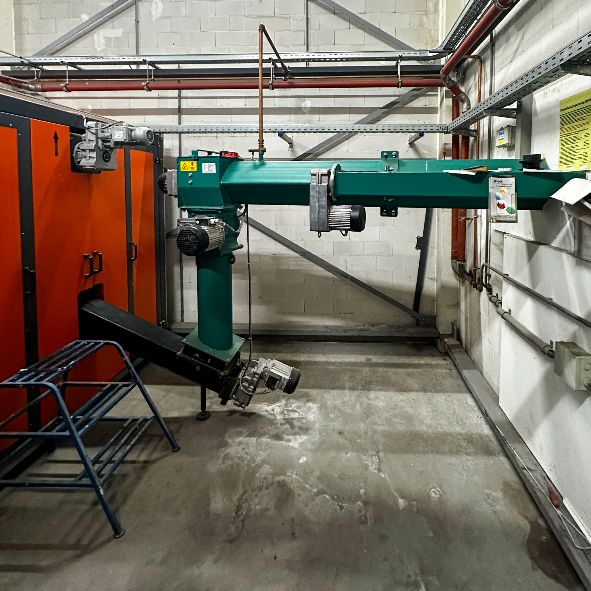 heizomat-rhk-ak Austragungssystem für Holzhackschnitzel und eine orange Heizomat Biomasseheizung