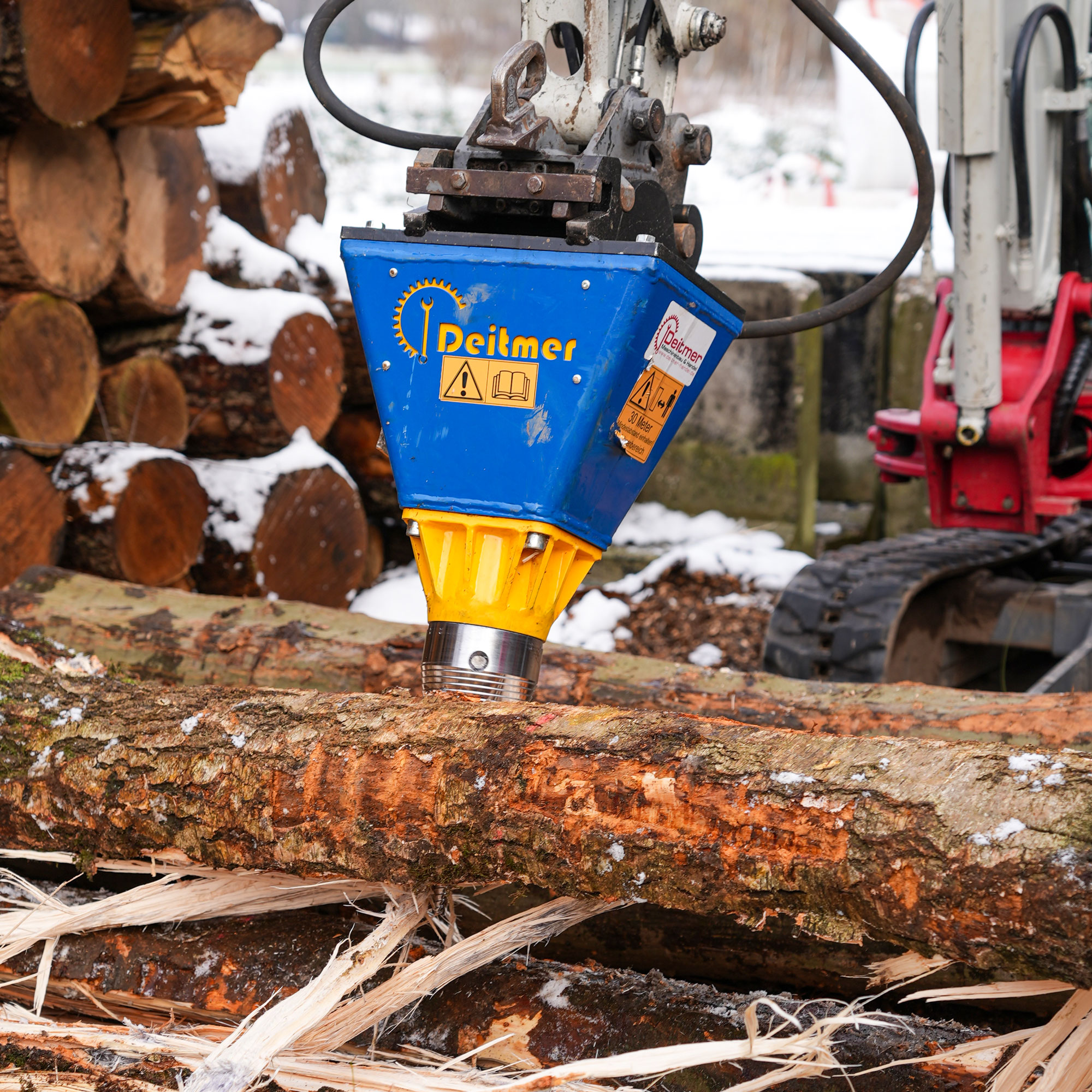 kegelspalter-holz-brennstoff Deitmer Kegelspalter montiert an einem Minibagger beim Spalten von Baumstämmen
