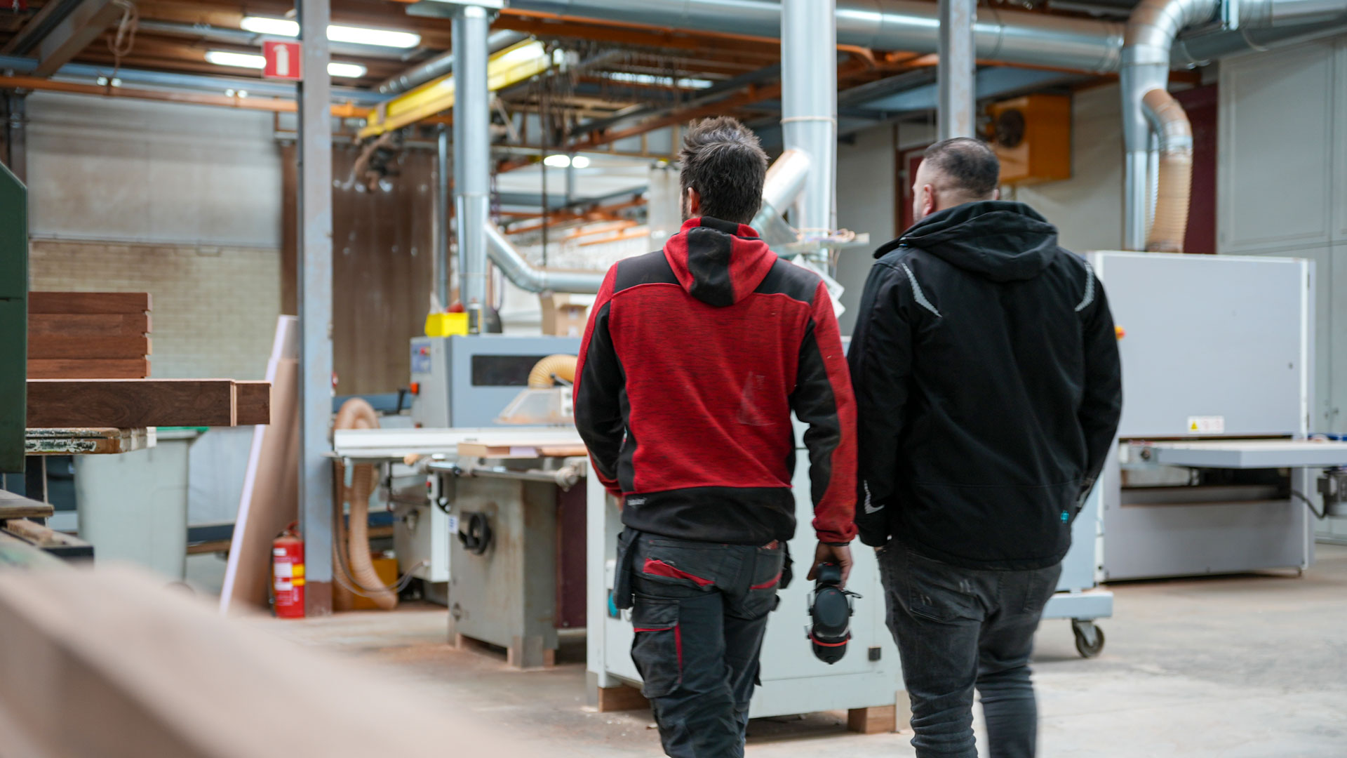 tischlerei-niederlande-heizomat Zwei Männer laufen durch eine Tischlerei