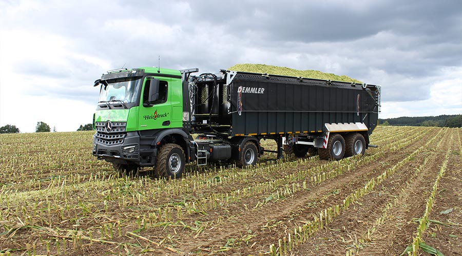 Heizotruck LKW mit Demmler Anhänger bei der Maisernete auf einem Feld