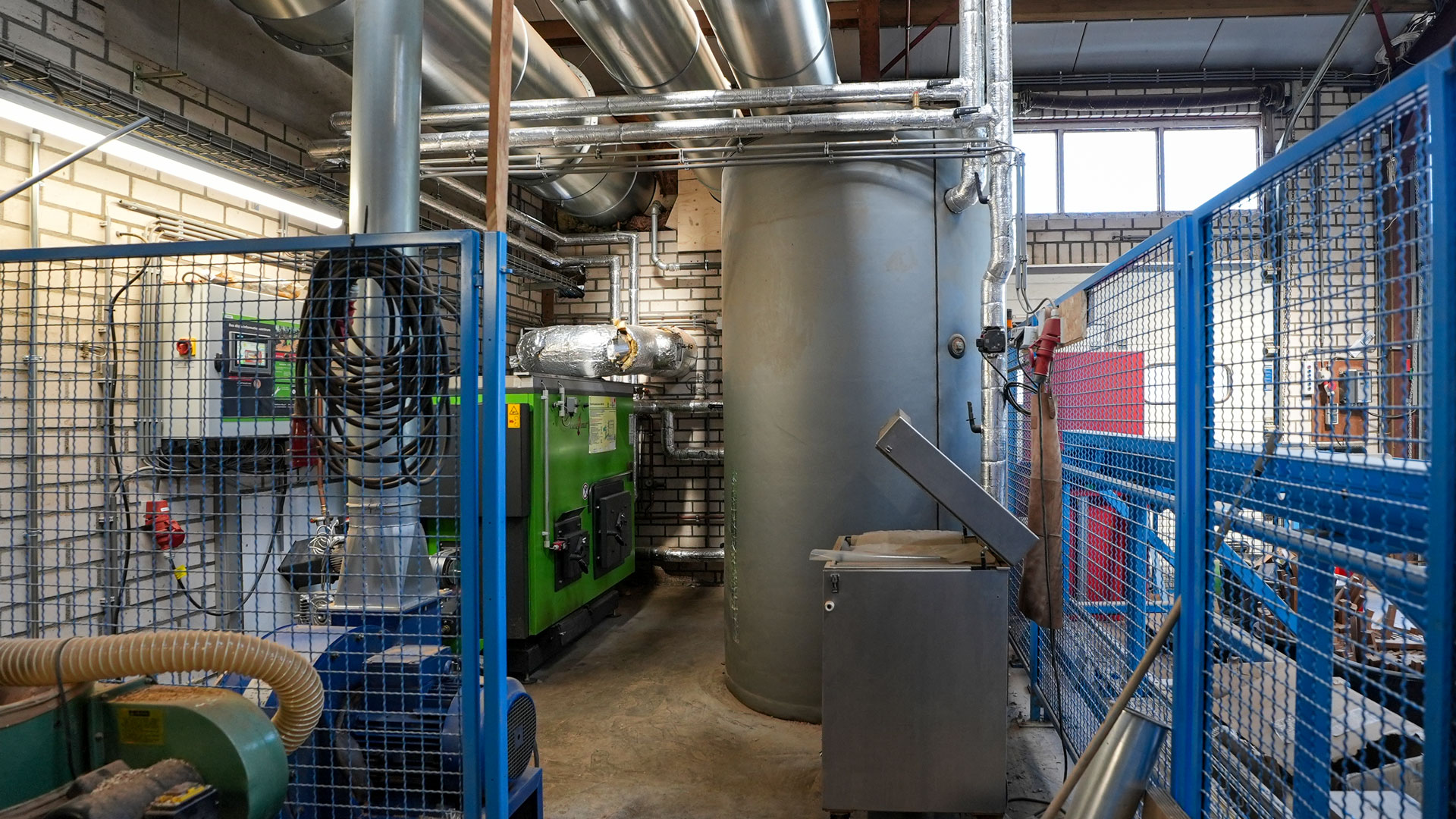heizzentrale-tischlerei-holzheizung 100 kW Späneheizung mit Schaltschrank, Pufferspeicher und Rauchgasrohr in einer neiderländischen Tischlerei